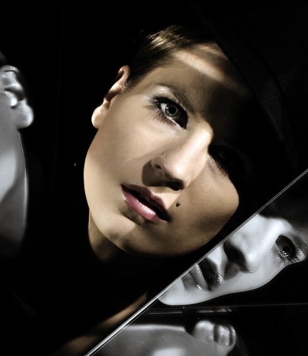A WOMAN'S FACE BEING REFLECTED IN A MIRROR