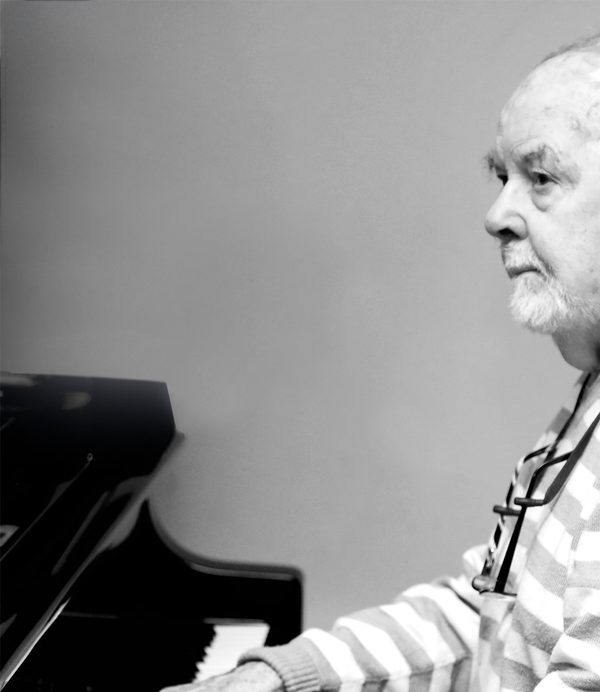 George Hall sitting at a piano