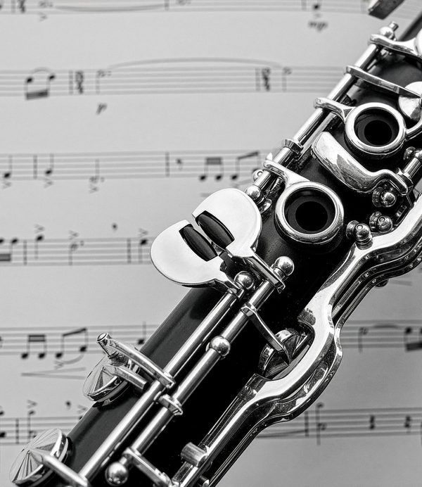 Close up of the keys on a clarinet placed on top of sheet music.