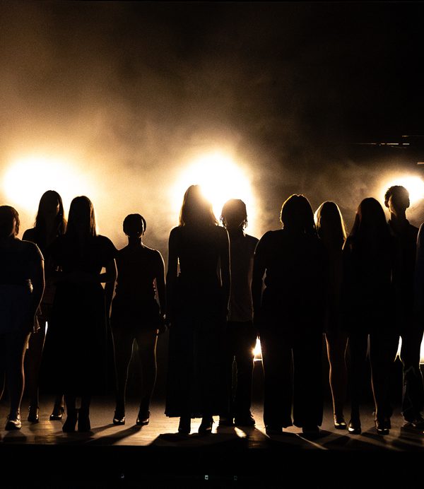 Students backlit on stage.
