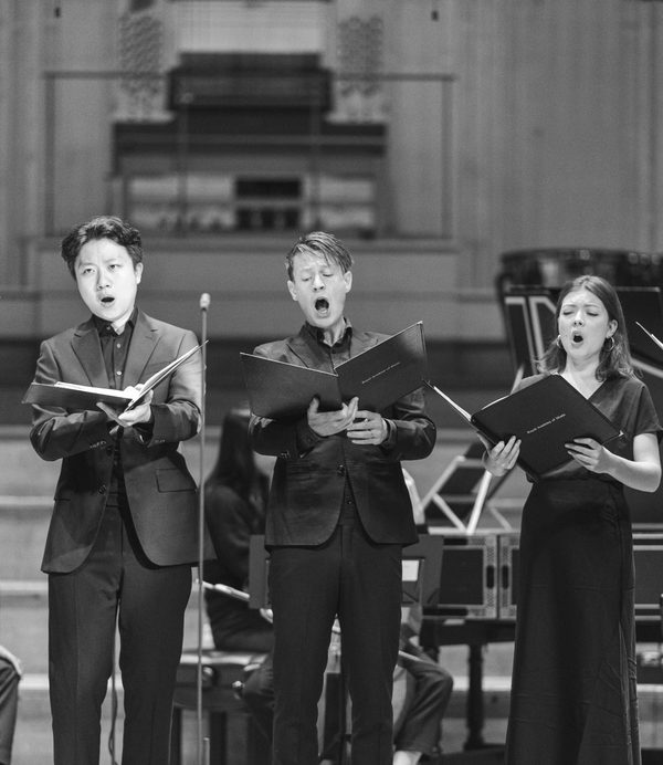 Five singers mid-note reading score.