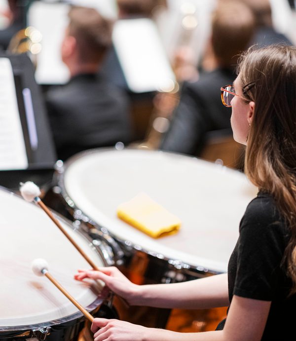 A timpanist viewed from over the shoulder, mid-concert.