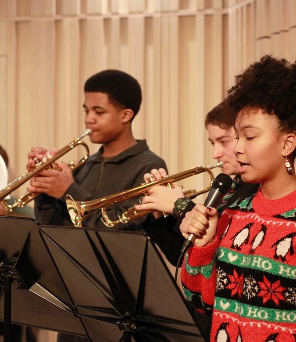 Three brass players and a singer in a concert by the widening participation department