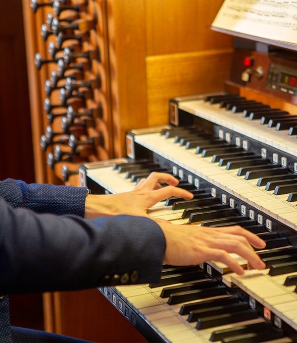 Hands on an organ keyboard.