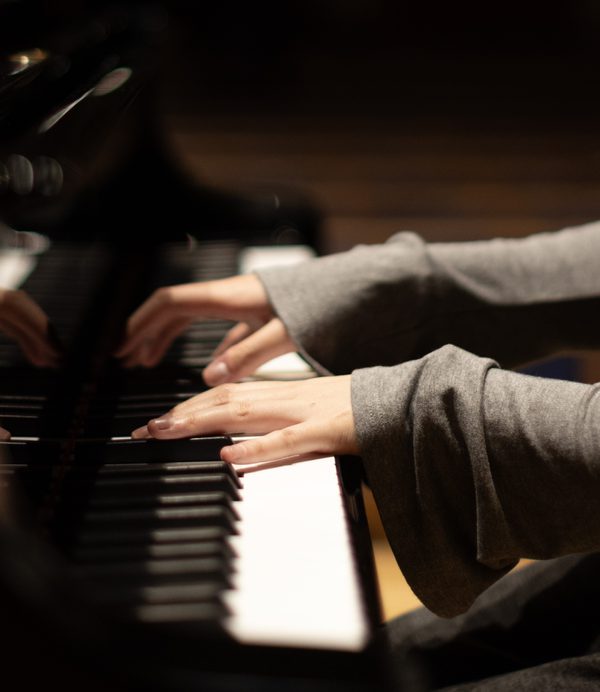 Hands on a piano keyboard.