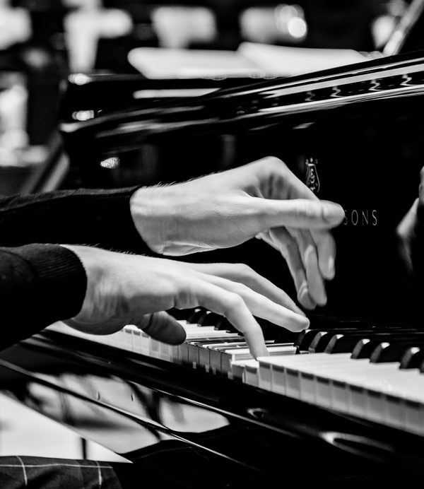 Hands on a piano keyboard.