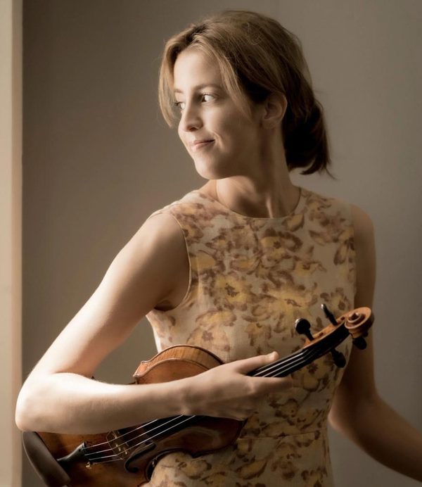 Vilde Frange holding a violin whilst looking to her right