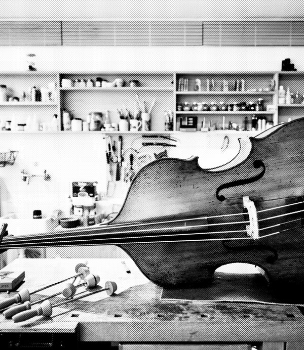 black and white image of a cello in the museum luthier workshop's table