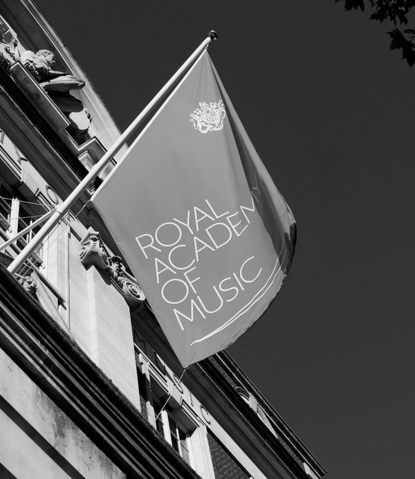 Black and white photo of the flag outside the main entrance of the building