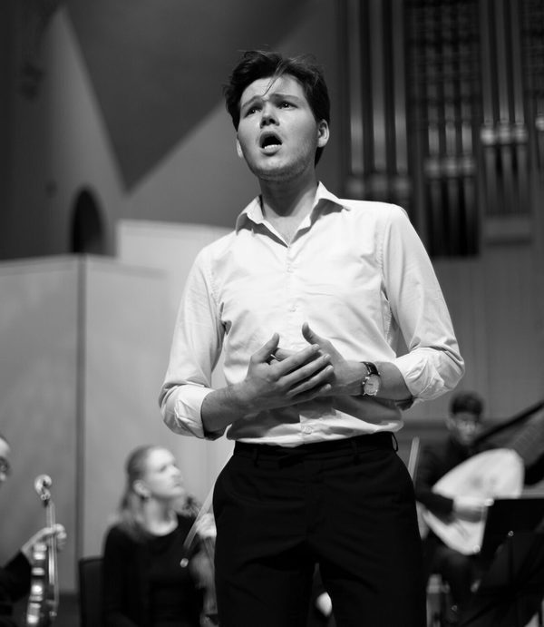 black and white picture of an academy singer mid note with an orchestral background