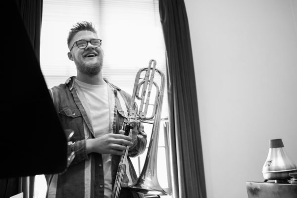 A bass trombone player smiling in a lesson.