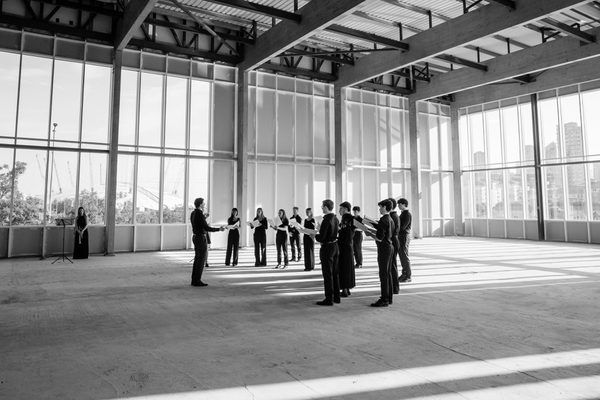 A choir and choral conductor in a large, open indoor space.