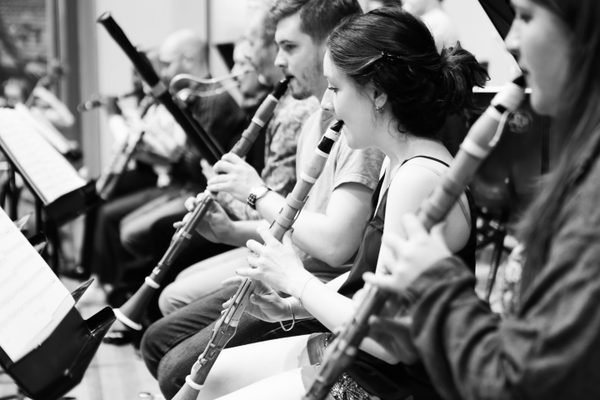 A row of historical clarinet players in rehearsal.