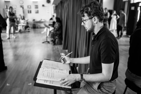 A musical director student makes notes on sheet music.