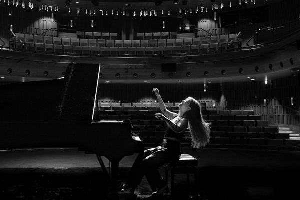 A pianist in an empty auditorium.