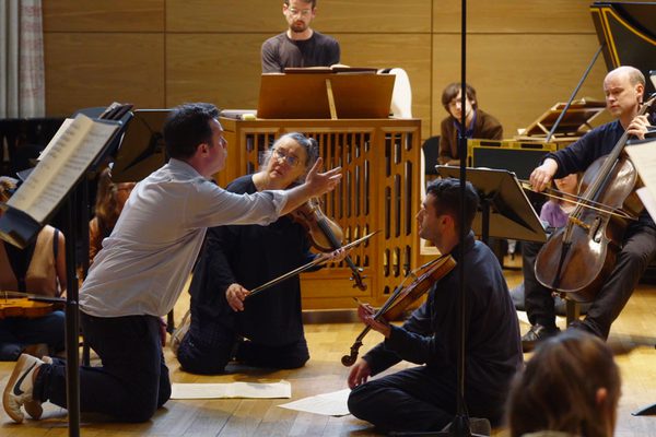 Musicians playing and singing on their knees during the performance of St John Passion
