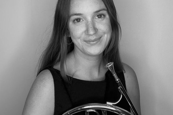 Black and white portrait of Eleanor Blakeney holding a French Horn