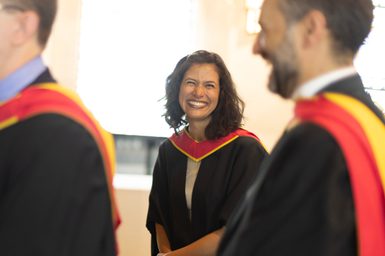 A portrait of Elena Urioste at the Royal Academy of Music's graduation ceremony. She is smiling and wearing graduation gowns.