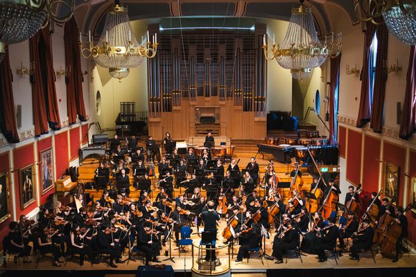 An image of the Academy Symphony Orchestra in rehearsal on the stage of the Duke's Hall