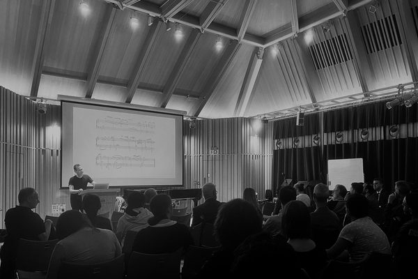 A presenter delivers a lecture to an audience