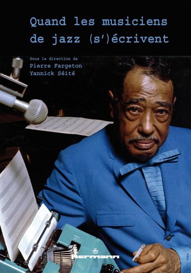 A musician leaning against a desk next to a typewriter