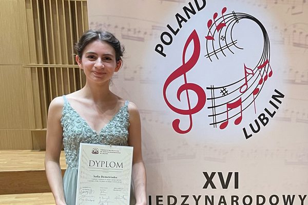 Junior Academy student Sofia Demetriades is pictured smiling, holding her certificate for winning the violin competition