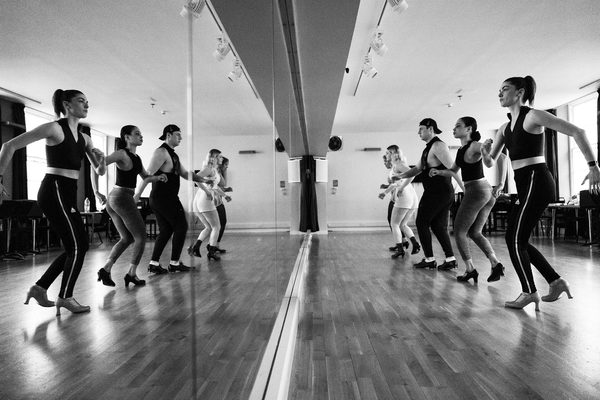 Students rehearse in a row, in front of a mirror