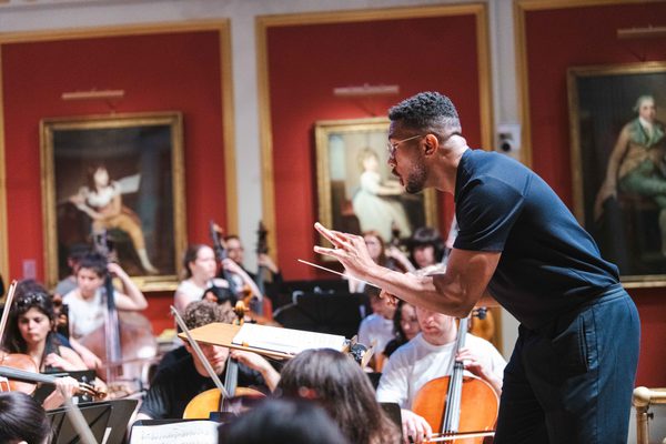 Roderick Cox on stage conducting an orchestra
