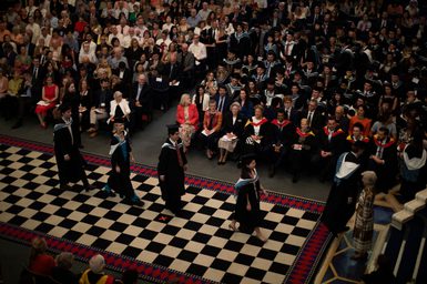 A graduation ceremony procession observed from a balcony