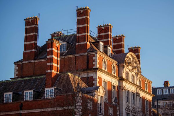 The Academy's red brick building with chimneys.