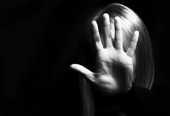 A women holds her hand up in front of her face