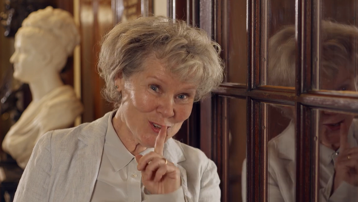 Imelda Staunton stands in front of a Royal Academy of Music practise room, with a finger against her lips