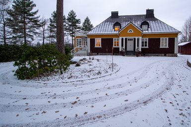 A house in a snowy setting with trees