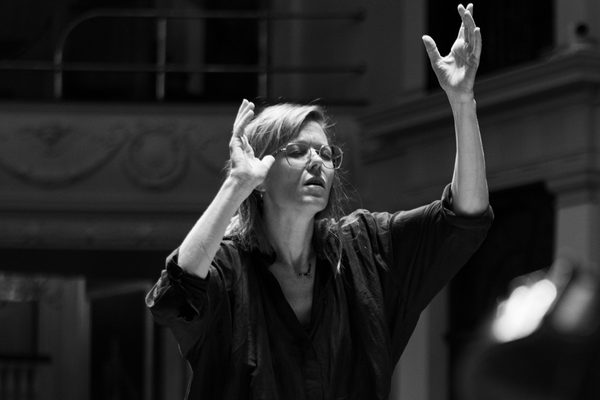 A black and white image of Barbara Hannigan conducting on stage