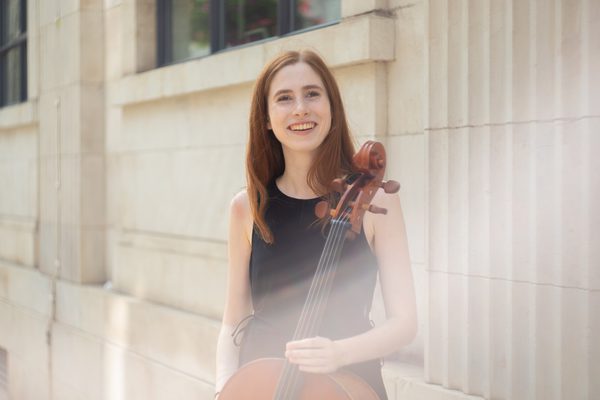 Image of Jessica Abrahams holding a cello, smiling