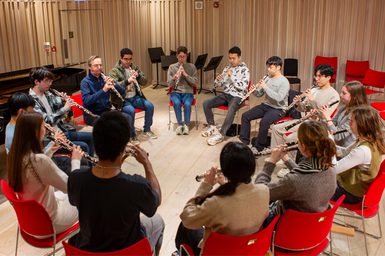 Jonathan Kelly and a group of Academy students sat in a circle, all playing oboes