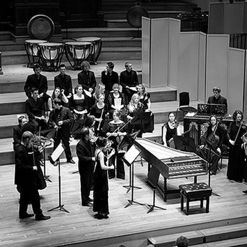 An ensemble of historical performance performers on stage.