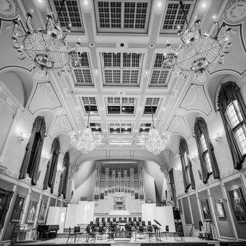 The stage of an empty concert hall with an organ in the background.