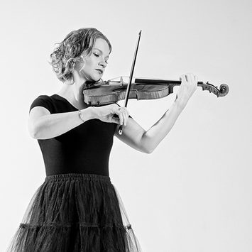 Portrait of a violinist performing against a white background.