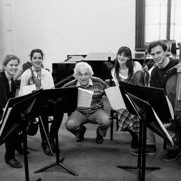 A string quartet and conductor pose for a photo.