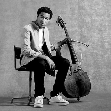 Sheku Kanneh-Mason sits with a cello.