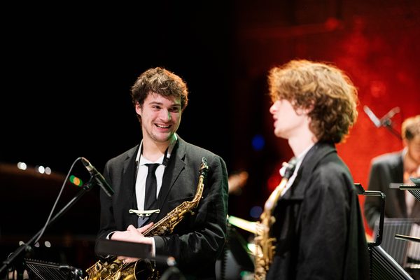 Jazz students converse on stage.