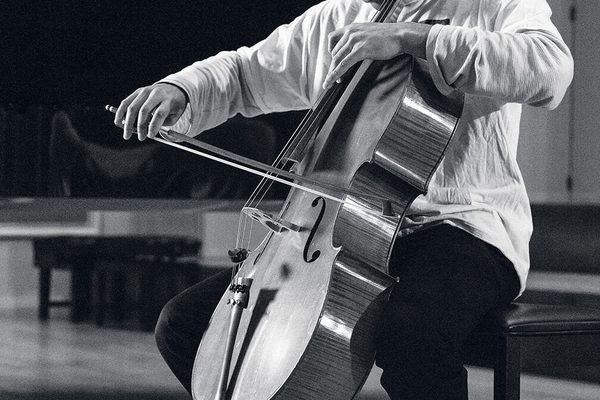 A close up of a cello student's finger movements, mid-performance (black and white).
