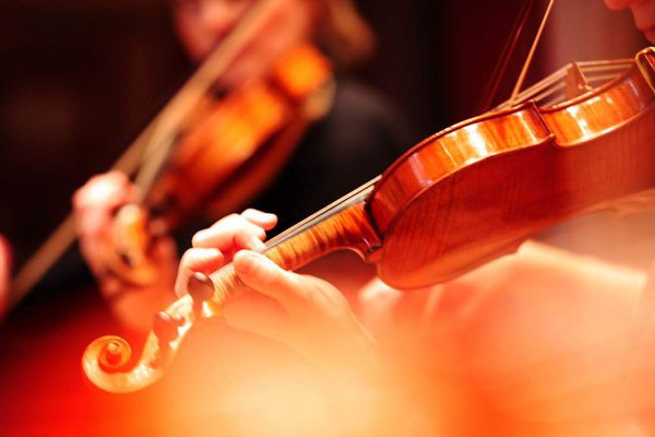 Close up of hands playing a violin.
