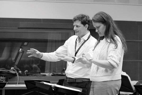 A close-up, black and white image of two conductors' hands in action.