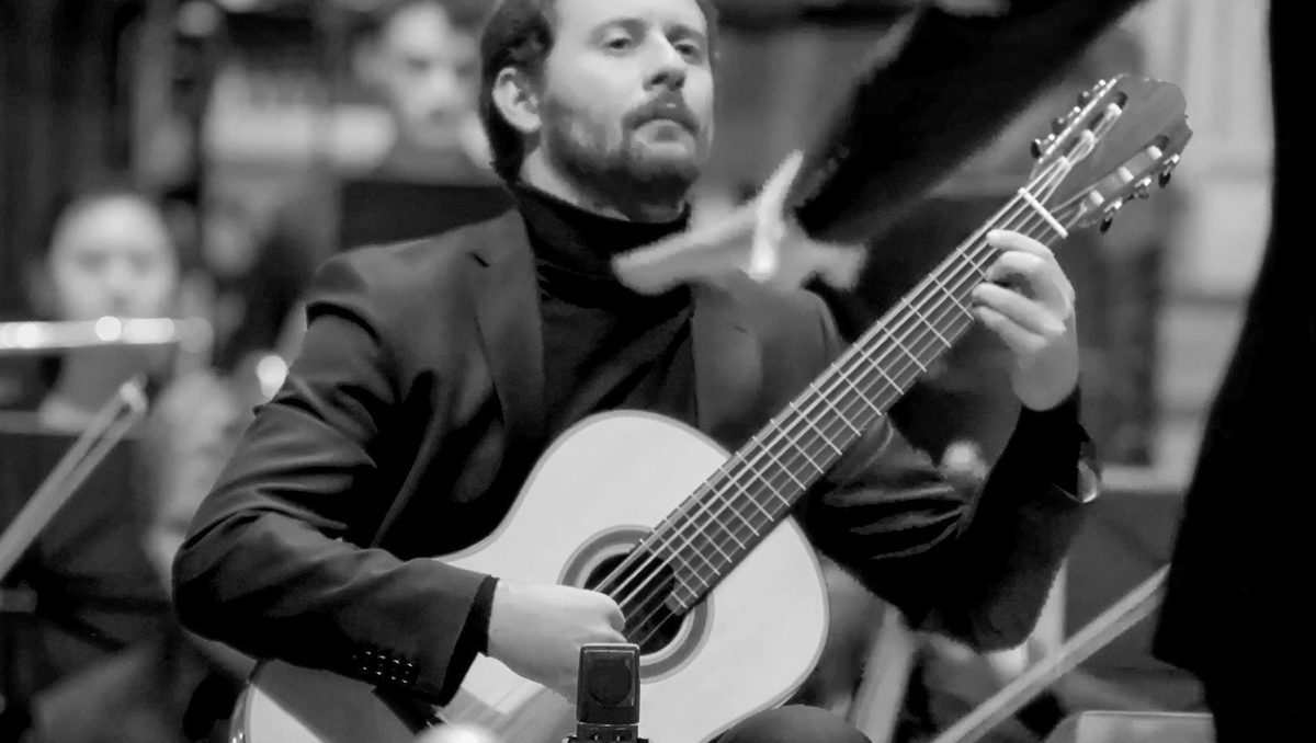 A guitarist plays alongside an orchestra,