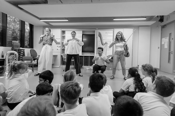 Musical practitioners lead a music class.