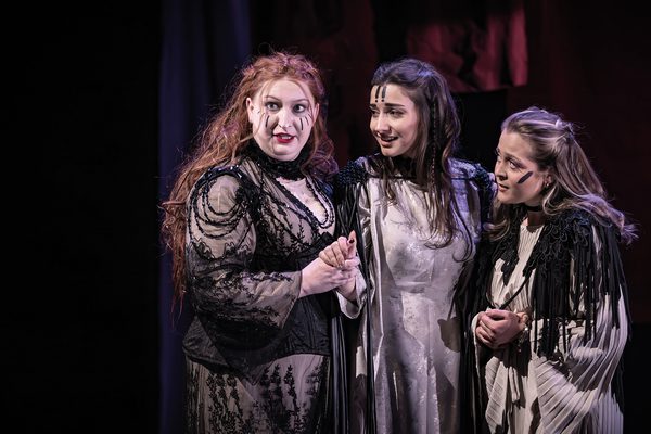 Three opera singers mid-performance.