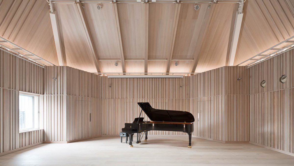 A piano in an elegant, empty recital hall.
