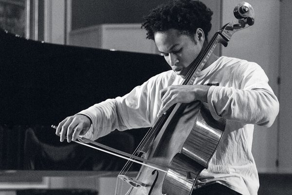 A close up of a cello student's finger movements, mid-performance (black and white).